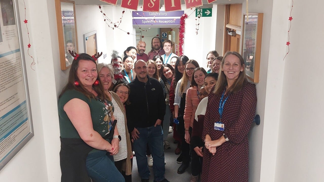 A group photo of lab staff in the corridor of the lab